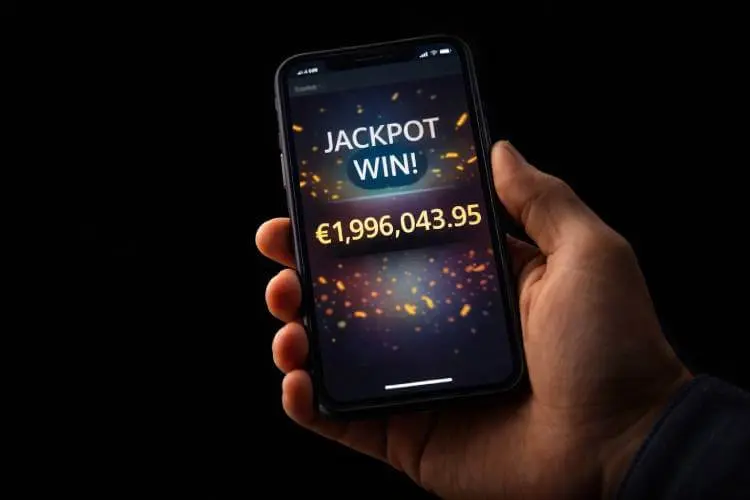 Hand holding a mobile phone showing a nearly €2 million progressive jackpot win